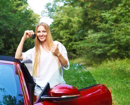 Beautiful blond young woman standing near a sports car photo