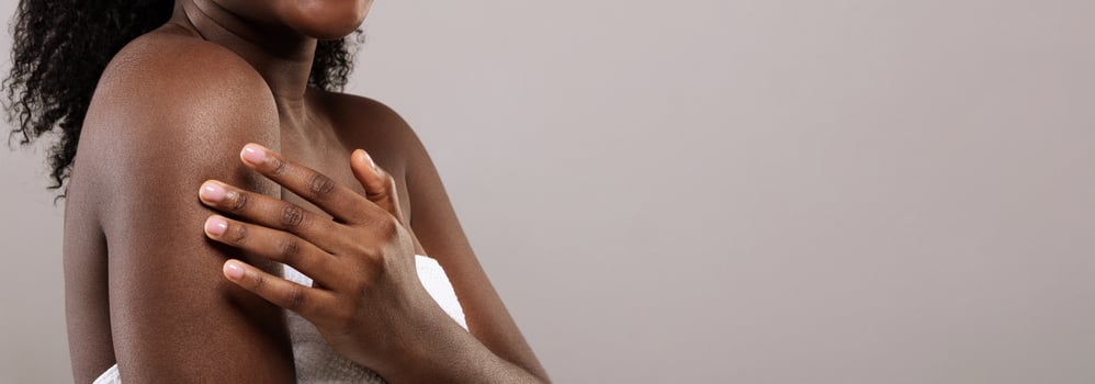 Cropped Image Of Young African American Female Touching Her Silk Soft Skin, Black Woman Enjoying Body Treatments And Self Care, Standing Wrapped In Towel On Grey Background, Panorama, Copy Space photo