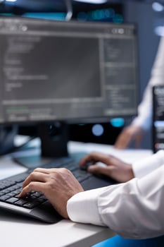 Admin in data center checking equipment performance on computer after upgrading infrastructure. Close up shot of IT employee doing maintenance on storage arrays in servers room photo