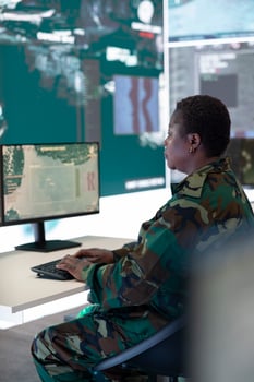 Female military IT agent examines satellite surveillance footage to process tactical data for a new federal mission. Woman uses global reconnaissance system to create future battlefield maps. photo