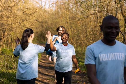 Joyful group of environmentalists doing high five with each other, saying congratulations and being satisfied with their teamwork efforts. Leader praising her colleagues, resilience. photo