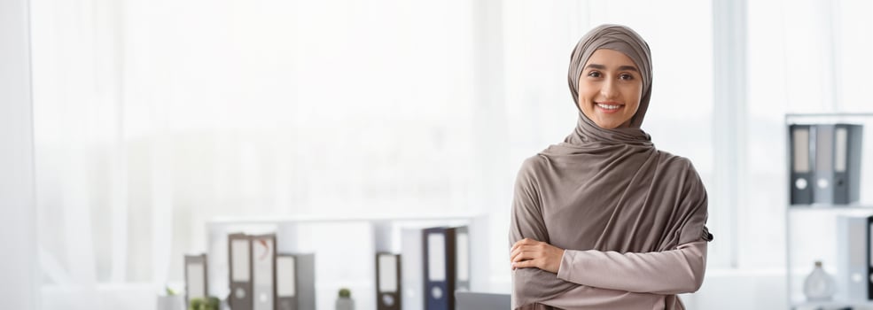 Business Career For Muslim Woman. Portrait Of Confident Arabic Businesswoman In Hijab Standing With Folded Arms Near Her Workplace In Office, Copy Space photo