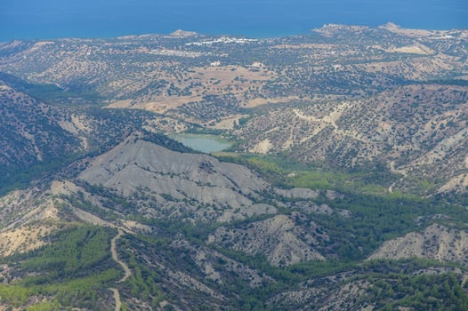 Aerial view of a mountainous landscape overlooking a tranquil bay in the distance on a clear day photo