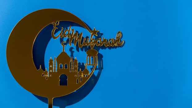 Crescent moon at top of mosque. Eid Mubarak text creative conceptual poster design for advertising branding. Mock up template for greeting card postcard. Ramadan Kareem background. Traditional muslim holiday. Copy space photo