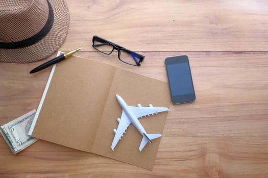Travel Essentials Airplane Model and Various Accessories on a Beautiful Wooden Table Surface photo