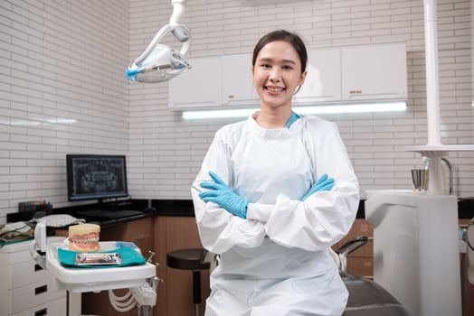 Portrait of one young beautiful Asian female dentist in uniform, Thai professional dental occupation worker, teeth healthcare, hygiene work in dental clinic hospital, happy smile, and look at camera. photo