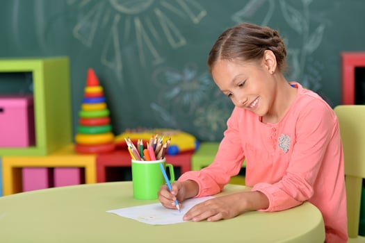 Portrait of cute little girl drawing at home photo