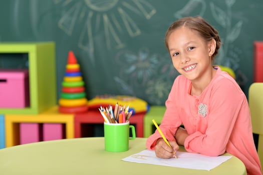 Portrait of cute little girl drawing at home photo