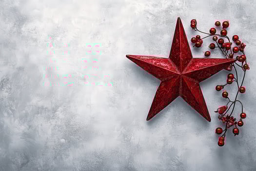 A striking red Christmas star is placed alongside a cluster of red berries, all set against a clean gray background. This festive arrangement captures the spirit of the holiday season. photo