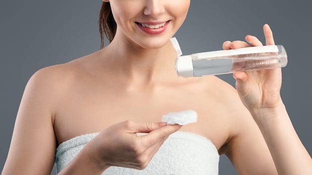 Facial Skincare. Red-Haired Millennial Woman Cleansing Skin Using Lotion And Cotton Pad Standing Over White Studio Background. Cosmetics And Spa, Skin Care For Youth Concept photo