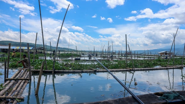 Semarang, 7 January 2023 - A view of Lake Rawa Pening on a clear day, with white clouds and blue sky. Some people can also be seen fishing. photo