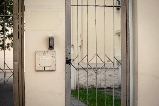 Closed metal doors in light concrete fence wall photo