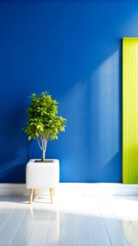A room with a bright blue wall and a green plant photo