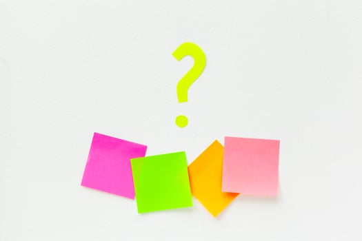 sticky notes with question marks over white photo