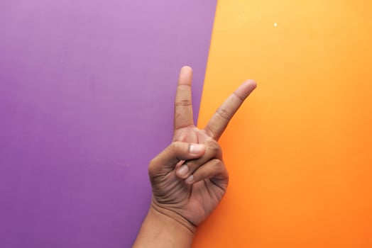 A Peace Sign Gesture Set Against a Vibrant and Colorful Background for Visual Impact photo