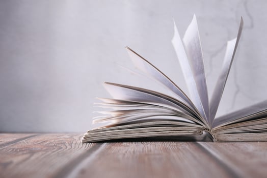 An Open Book Resting on a Wooden Table, Its Pages Seeming to Be in Motion and Dynamic photo