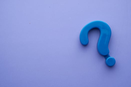 A Blue Plastic Question Mark Symbol Set Against a Light Purple Background, Creating Visual Interest photo