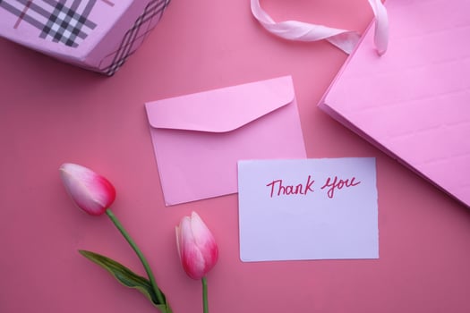 An Elegant Pink Thank You Note featuring a beautiful gift alongside lovely Tulips photo