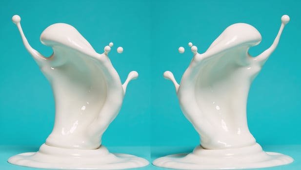 Milk splash reflected on bluegreen background mirrored photo
