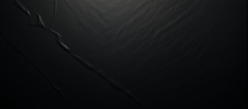 A black textured gradient background featuring an uneven matte surface photo