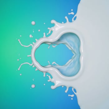 Milk splash reflected on bluegreen background mirrored photo