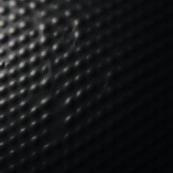 A black textured gradient background featuring an uneven matte surface photo