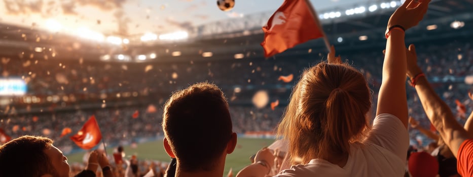 Excited fans celebrate a goal during a soccer match at the stadium in the evening under bright lights photo