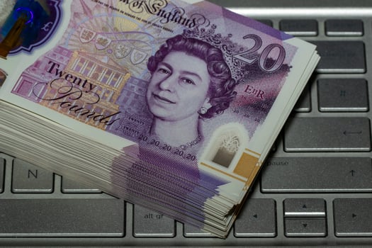 Stack of Twenty Pound Notes on Laptop Keyboard photo