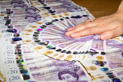 A person holding a stack of british pounds photo