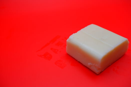 cube shaped cheese isolated on red background. mozzarella cheese that melts easily photo