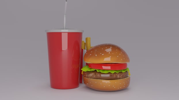 A hamburger and a drink next to each other photo