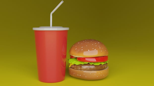 a hamburger with a drink and straw sitting on top of it photo