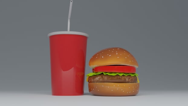 a hamburger with a drink and straw sitting on top of it photo