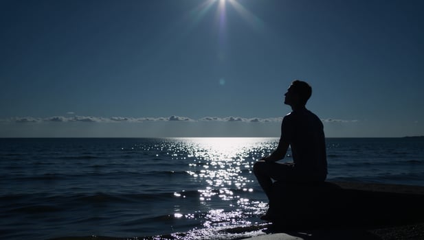 Lone figure contemplates under moonlit sky by waters edge photo