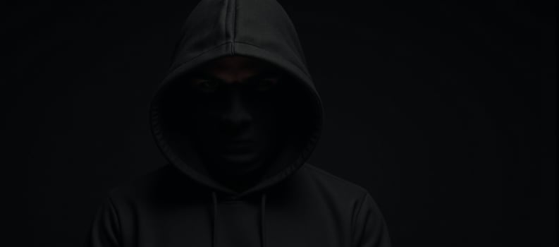 Computer Hacker Blackhooded figure in Dark Moody Background photo