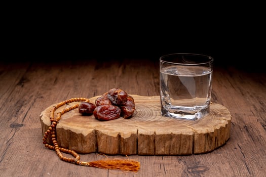 Many Date Palms are on bowls and cups of water and the Quran is on wooden tables, to wait for the time of Iftar, with the concept of ramadan Muslims around the world. photo