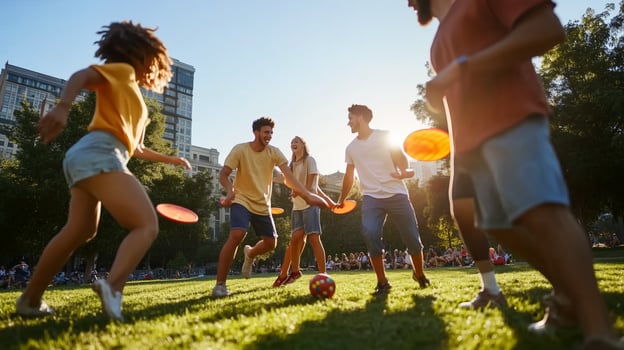 Group of young friends playing frisbee and soccer in a sunlit park during late afternoon in an urban setting photo