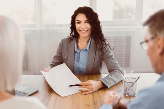 Senior Health Insurance Concept. Mature couple making agreement with sale agent, female advisor offering to sign contract photo