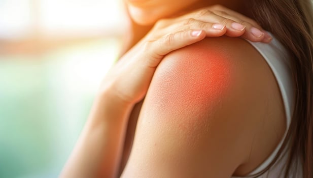 Close up of a woman with shoulder pain, highlighted in red. Concept of injury, muscle strain, or medical condition. photo