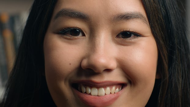 Close-up female face happy asian woman girl lady client customer smiling with white healthy teeth looking at camera satisfied with service dental clinic affordable medicine healthcare dentistry photo