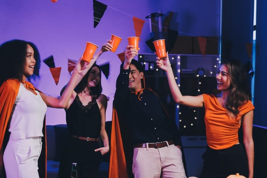 Joyful office Halloween party with coworkers in costumes, celebrating with drinks and laughter, fostering teamwork and festive spirit photo
