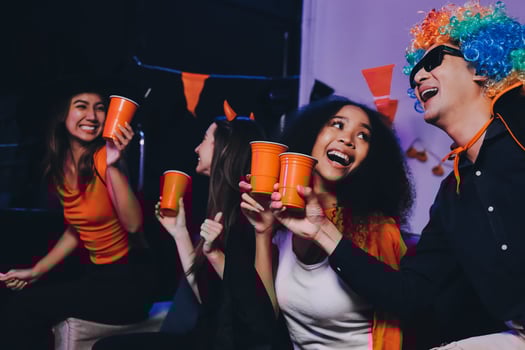 Joyful office Halloween party with coworkers in costumes, celebrating with drinks and laughter, fostering teamwork and festive spirit photo