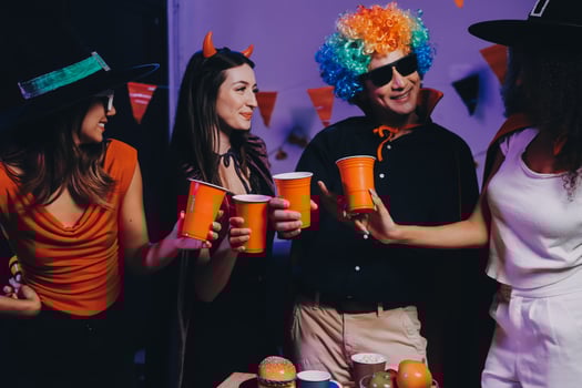 Joyful office Halloween party with coworkers in costumes, celebrating with drinks and laughter, fostering teamwork and festive spirit photo