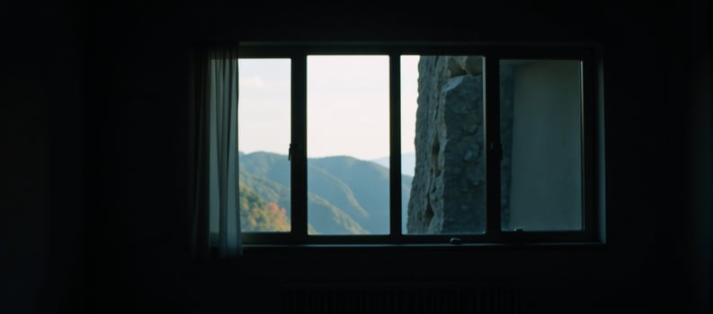 A dimly lit space featuring a large window photo