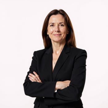 A professional businesswoman stands confidently against an isolating white backdrop dressed in a black suit with crossed arms photo