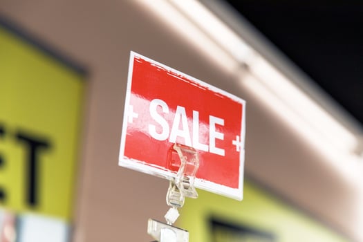 Vibrant red sale sign in retail store promoting discounts and shopping deals photo
