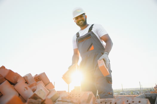 Indian Construction worker in uniform and safety equipment have job on building photo