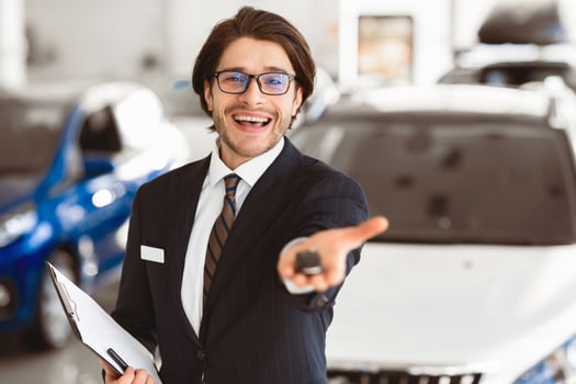 Car Rent. Handsome Agent Showing Auto Key Standing In Automobile Rental Office. Copyspace, Shallow Depth photo