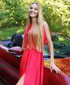 Beautiful blond young woman standing near a sports car photo