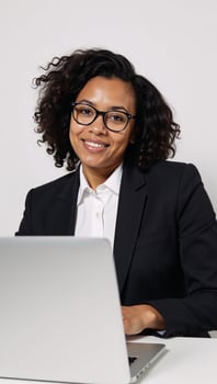 Isolated portrait of an Afrocurlyhaired businesswoman working intently on her laptop white background photo